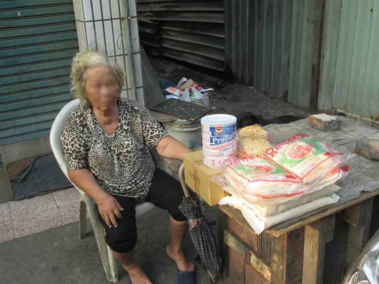 她住在這，不是身後的房子，而是房子與另一堵圍牆的夾縫中。