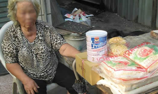 她住在這，不是身後的房子，而是房子與另一堵圍牆的夾縫中。