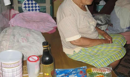 小小的斗室哩，擺著一張木板床，一旁是簡陋的廚房，飯桌上有些未吃完的麵條跟空罐頭。